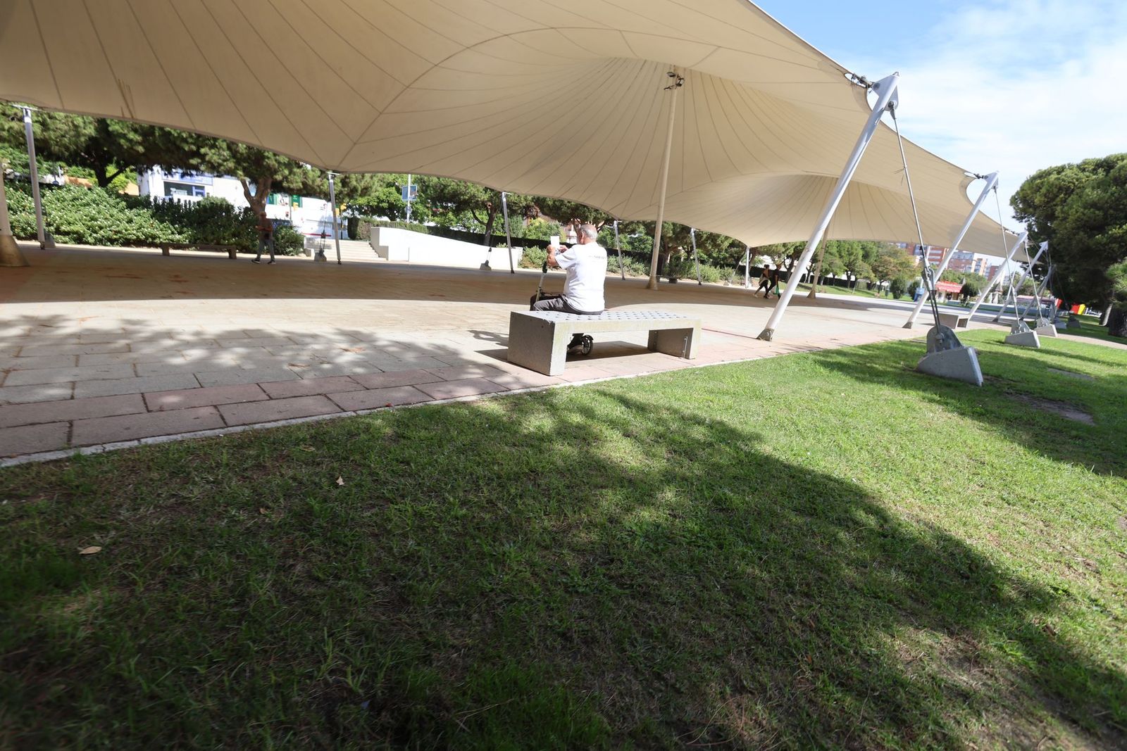 Ciudadano sentado en un banco en un espacio público de Huelva.