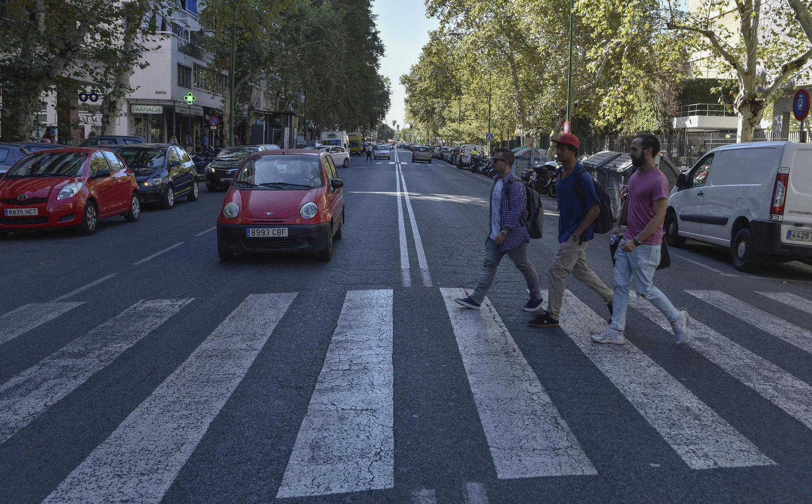 Tres jóvenes cruzan un paso de peatones de la avenida Reina Mercedes.