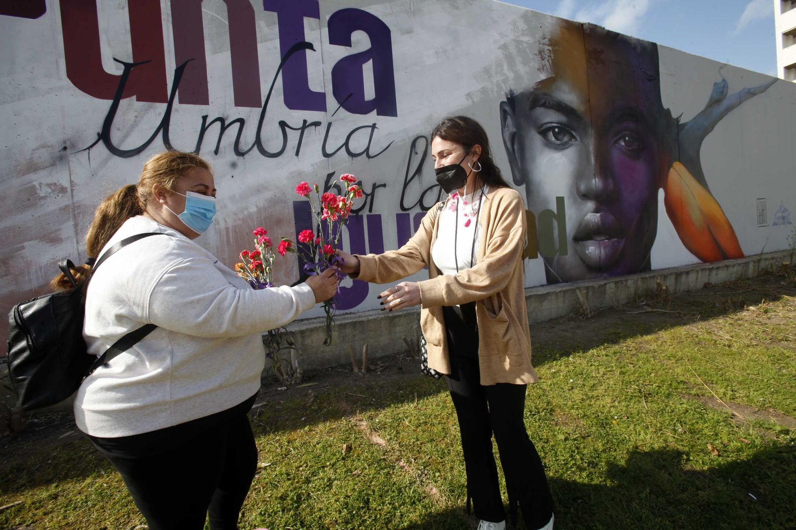 Reparto de flores por el acto de inauguración del mural de la igualdad. Imagen de archivo.