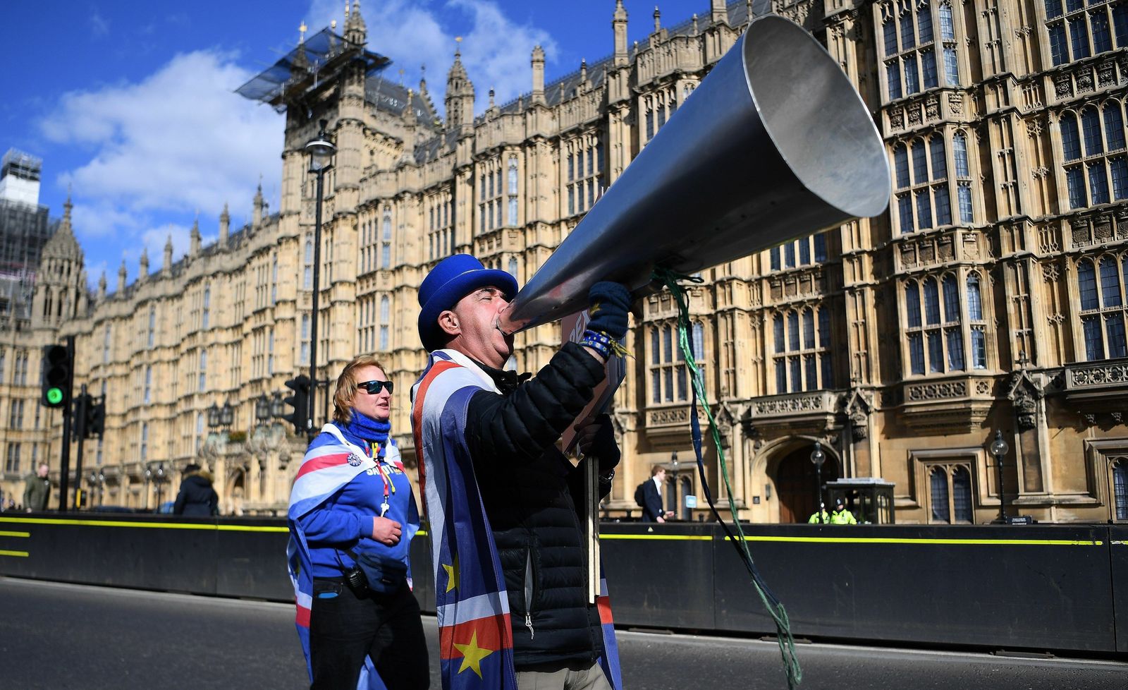 Dos activistas a favor de la Unión Europea se manifiestan frente al Parlamento británico.