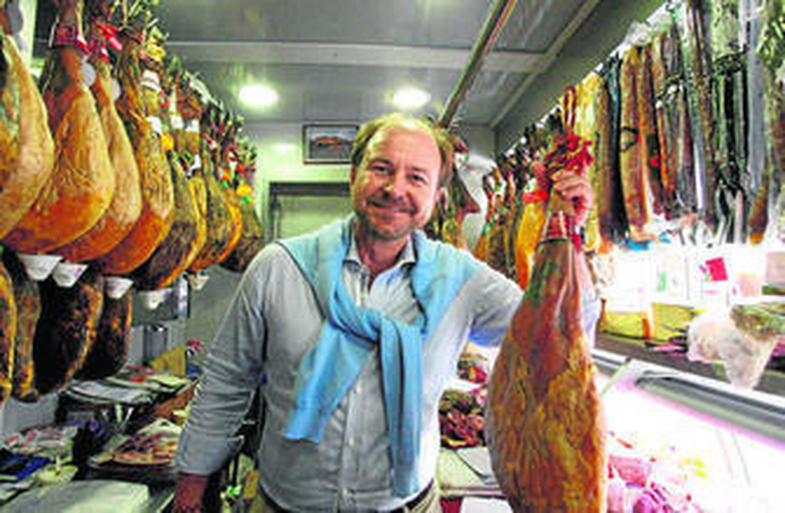 Guillermo García-Palacios Álvarez, en el mercado de El Carmen de la capital, con uno de los jamones de la DO Jamón de Huelva, que él preside.
