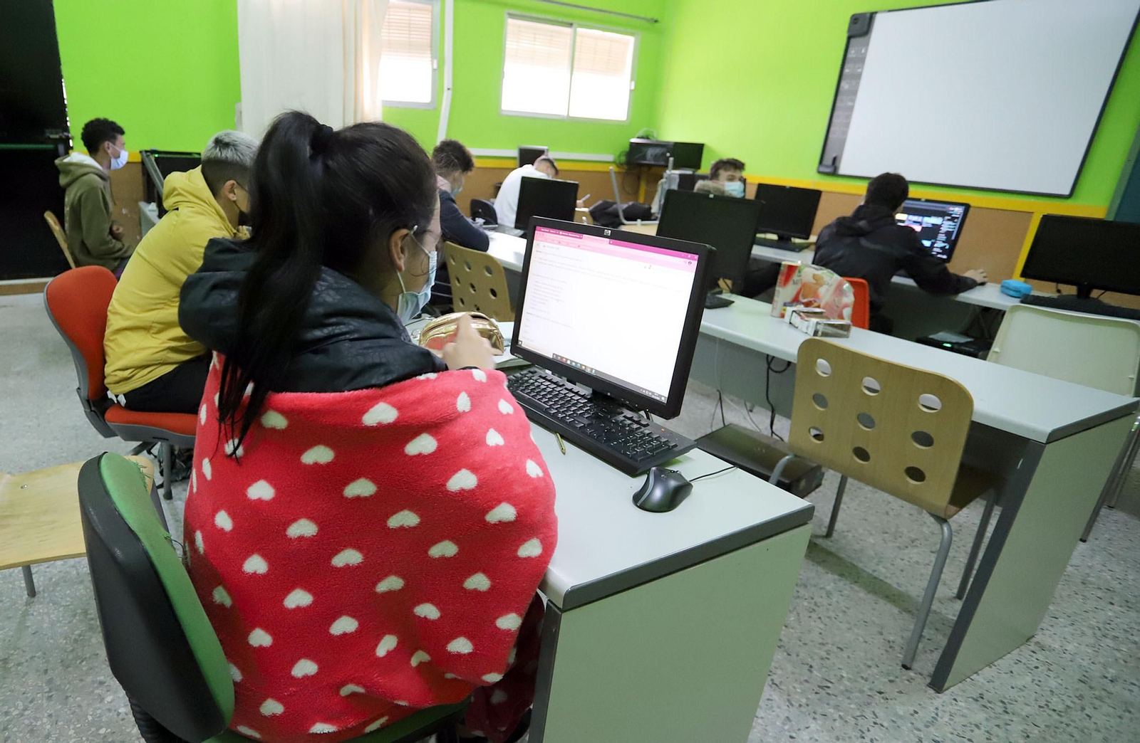 Un grupo de alumnos sigue una clase con abrigos por las bajas temperaturas.