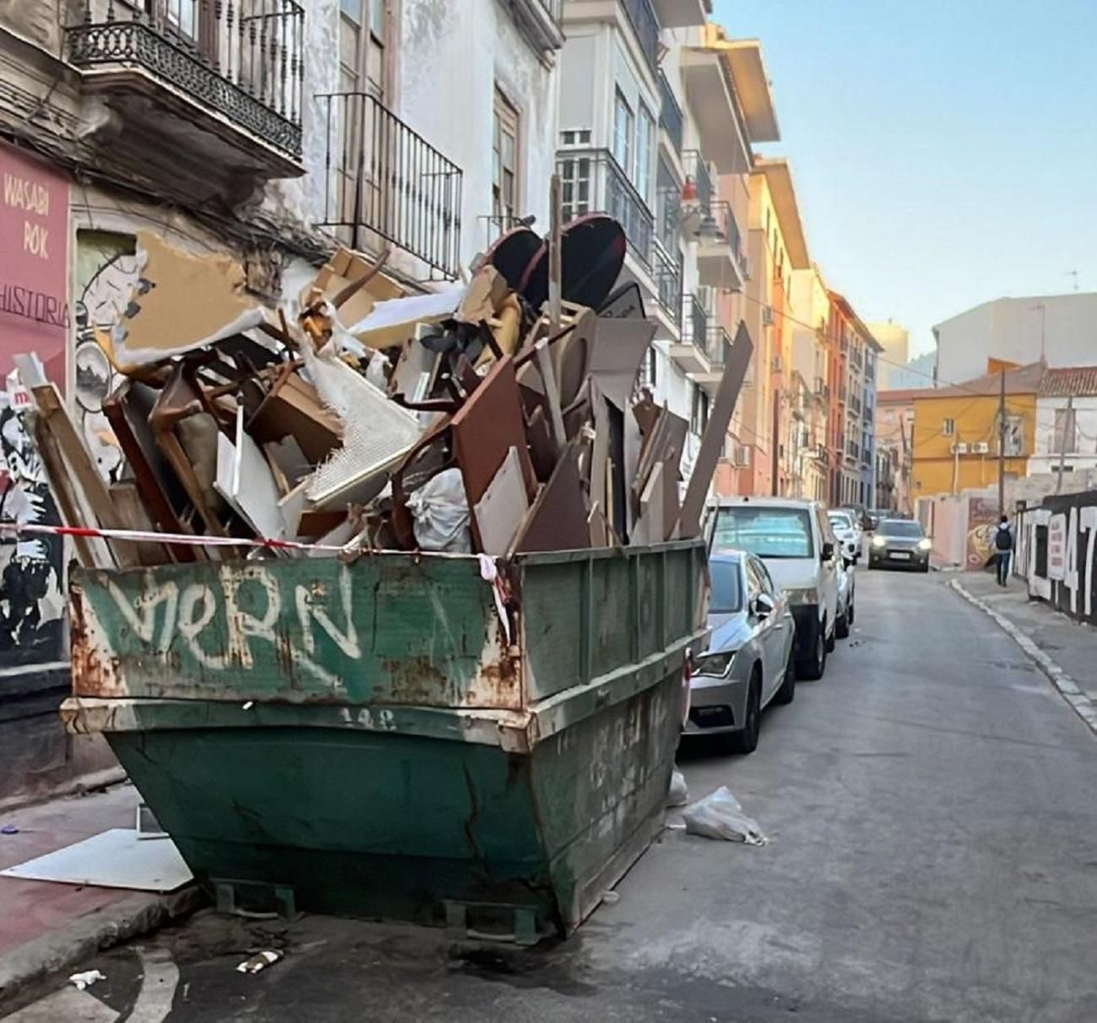 Un contenedor de obra, hasta los topes en una calle de Málaga.