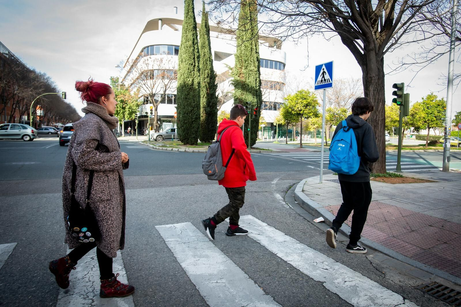 Noelia y sus dos hijos pasean por una calle de Sevilla.