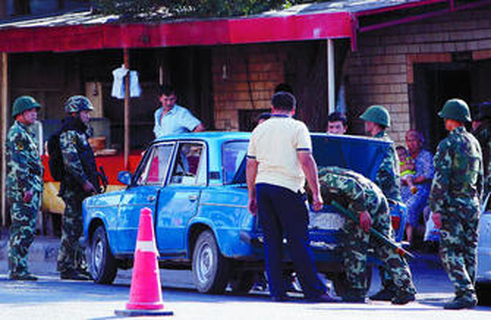 Fuerzas de seguridad chinas revisan el coche de un uigur en un control en una calle de Urumqi.