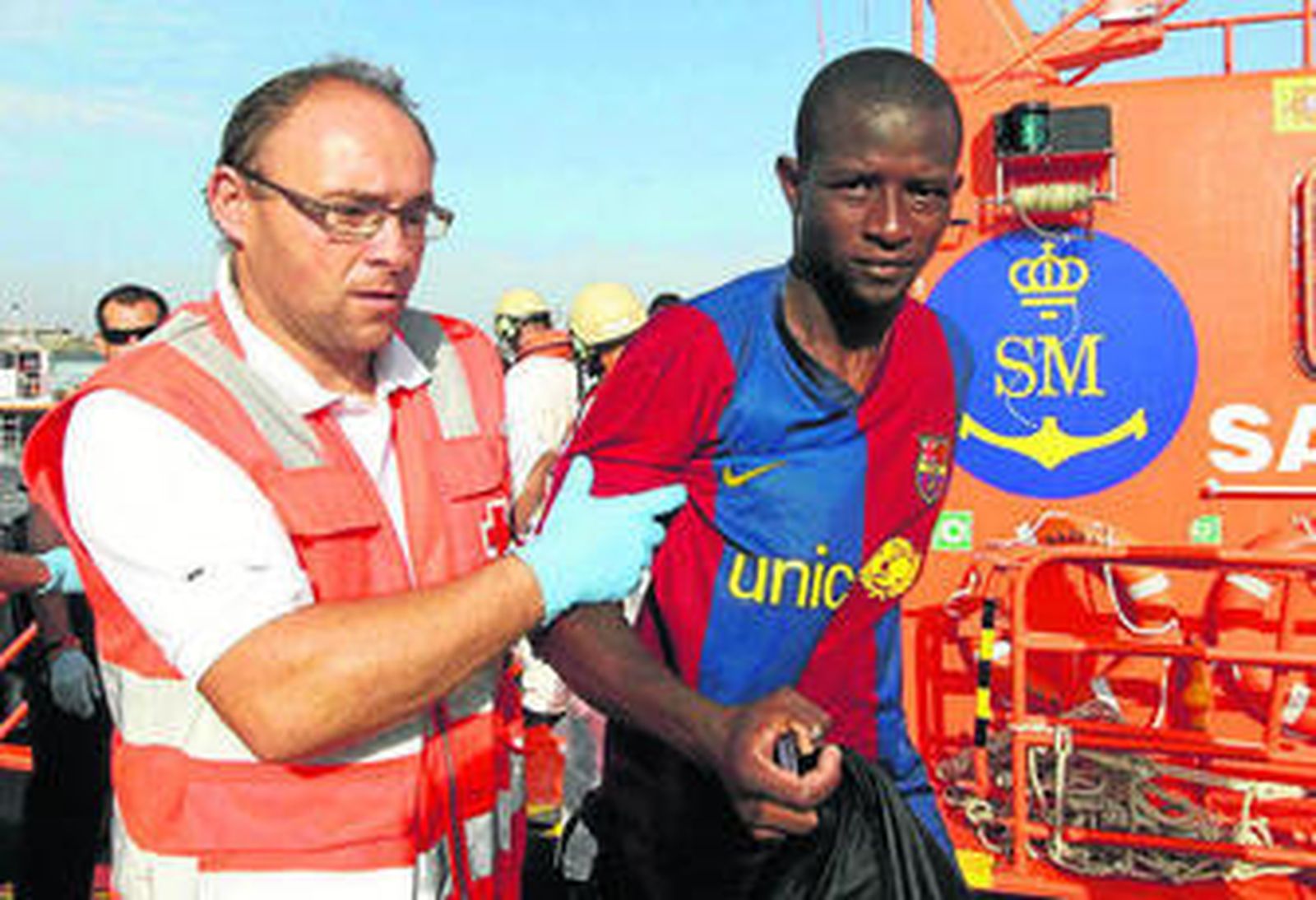 Un voluntario de Cruz Roja ayudando a un inmigrante ayer en Tarifa.