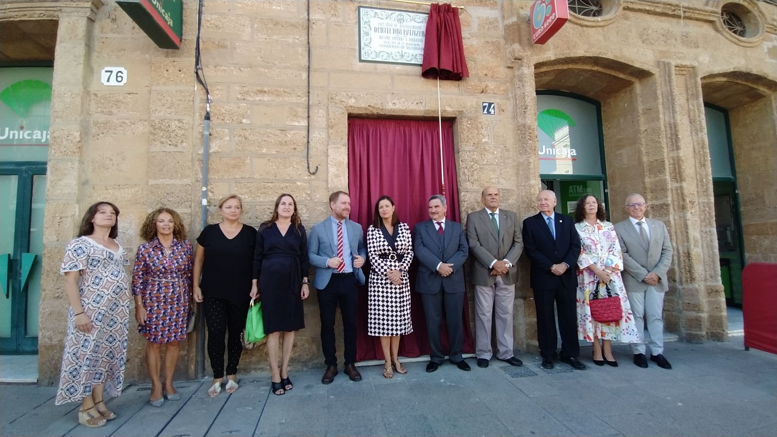 Asistentes al acto en homenaje al almirante Lobo posan debajo de la placa.