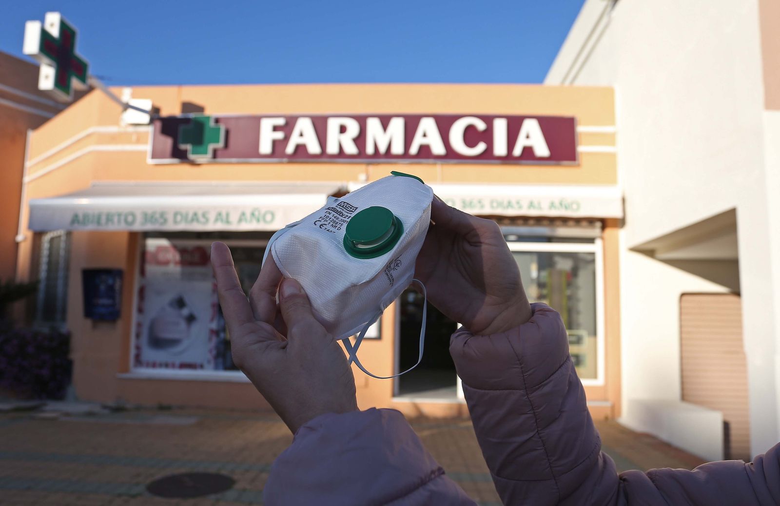 Una mujer muestra una mascarilla en Algeciras.