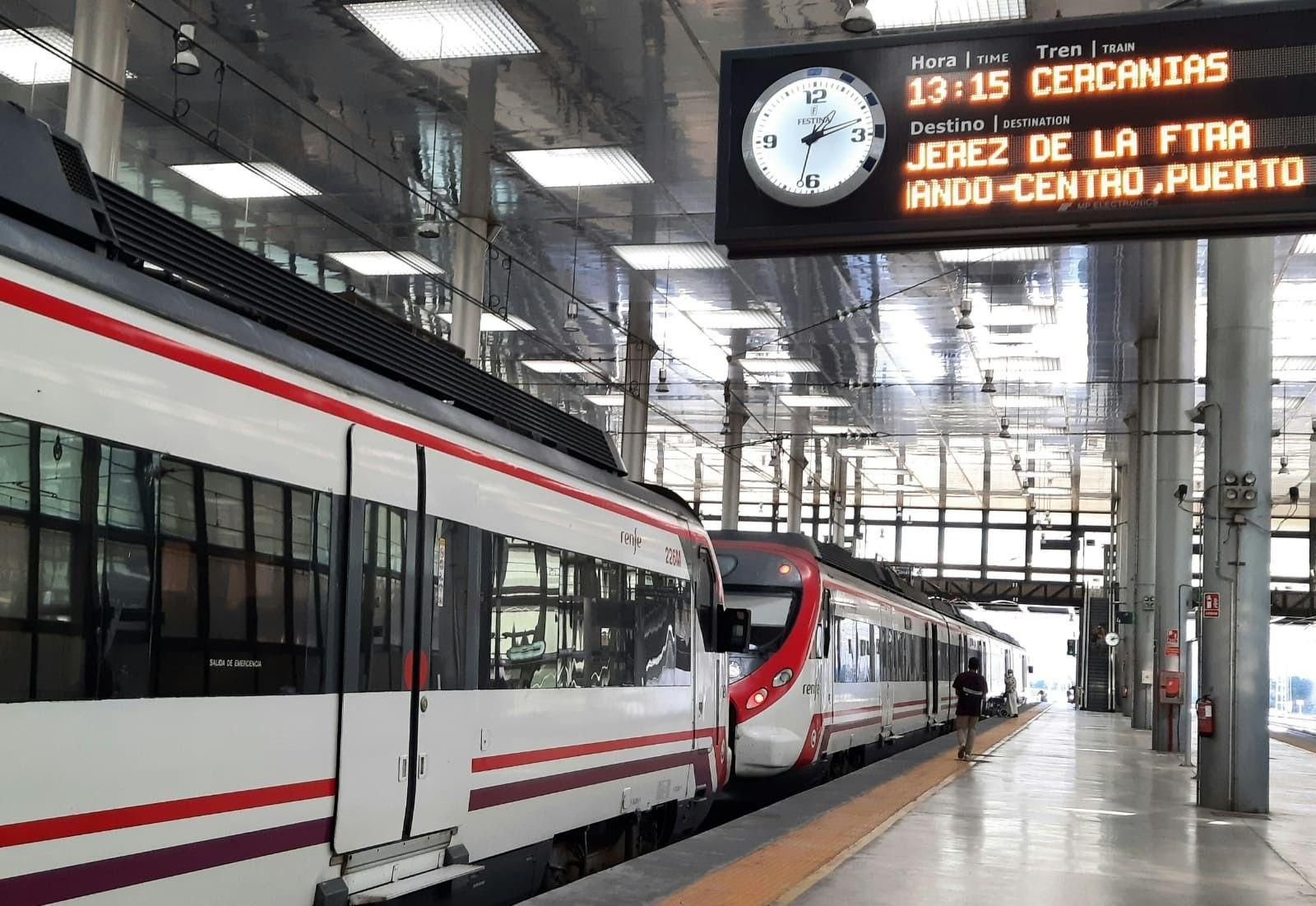 Tren de cercanías en el andén de la estación de Cádiz con el cartel anunciando las paradas y hora de salida.