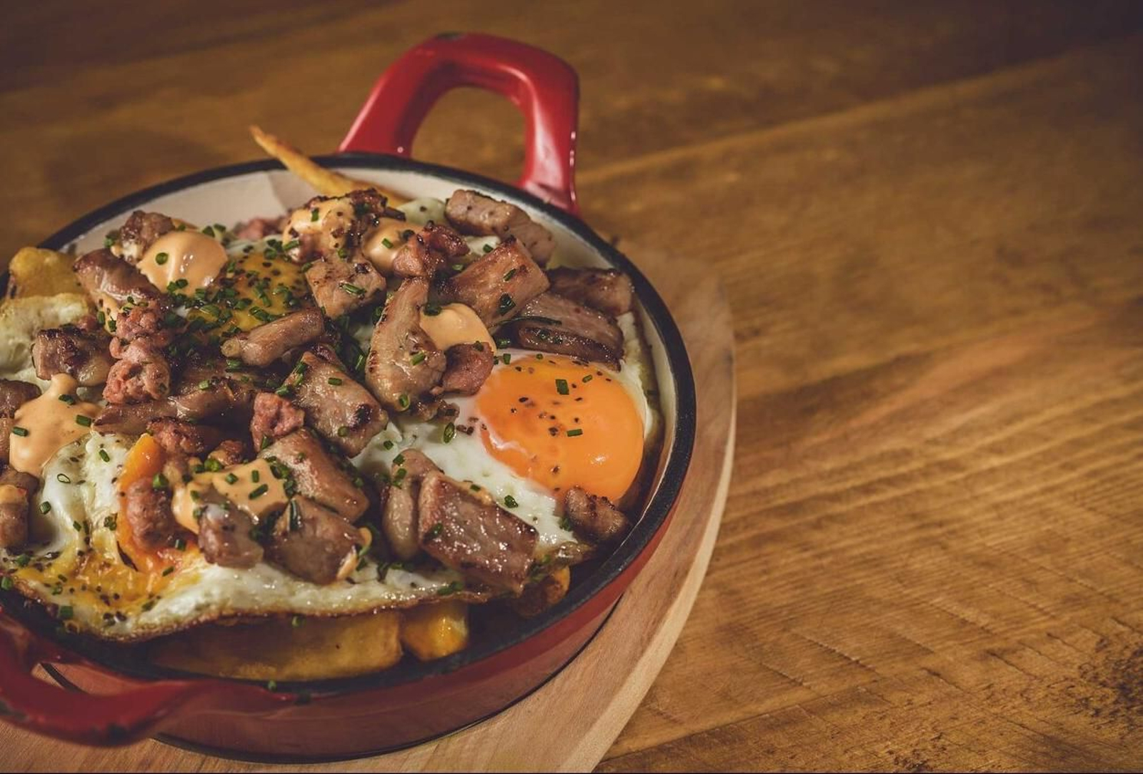 Huevos rotos de matanza con secreto ibérico y chorizo parrillero y su mayo de mojo.