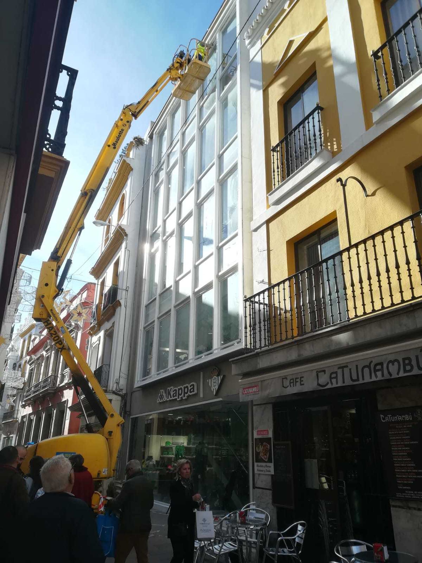 Momento de la retirada de la lona publicitaria de la tienda del Betis.