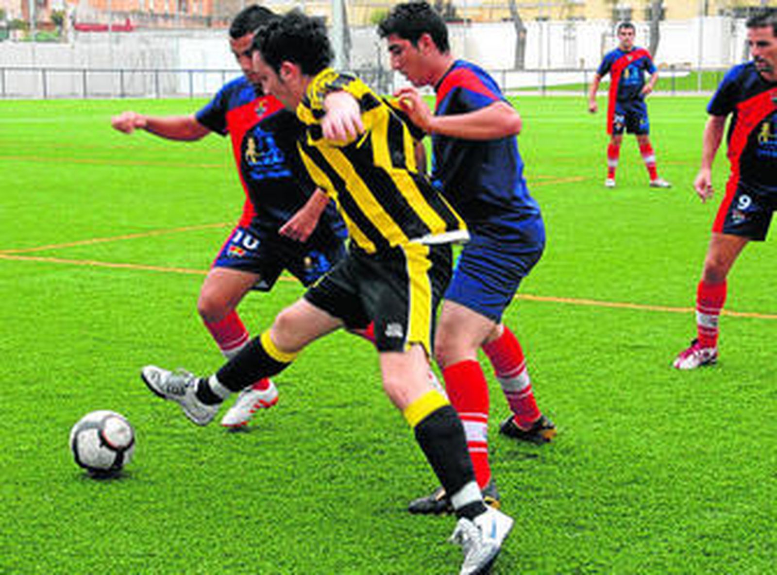 Dos defensores del Tarifa tratan de impedir que un jugador del Bazán se haga con el control del esférico.