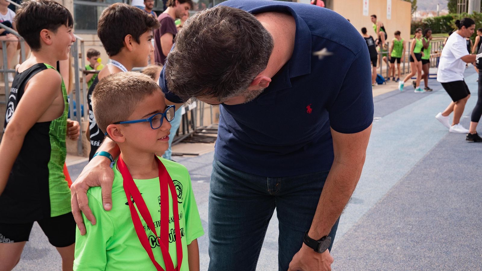 El alcade charla con un joven atleta.