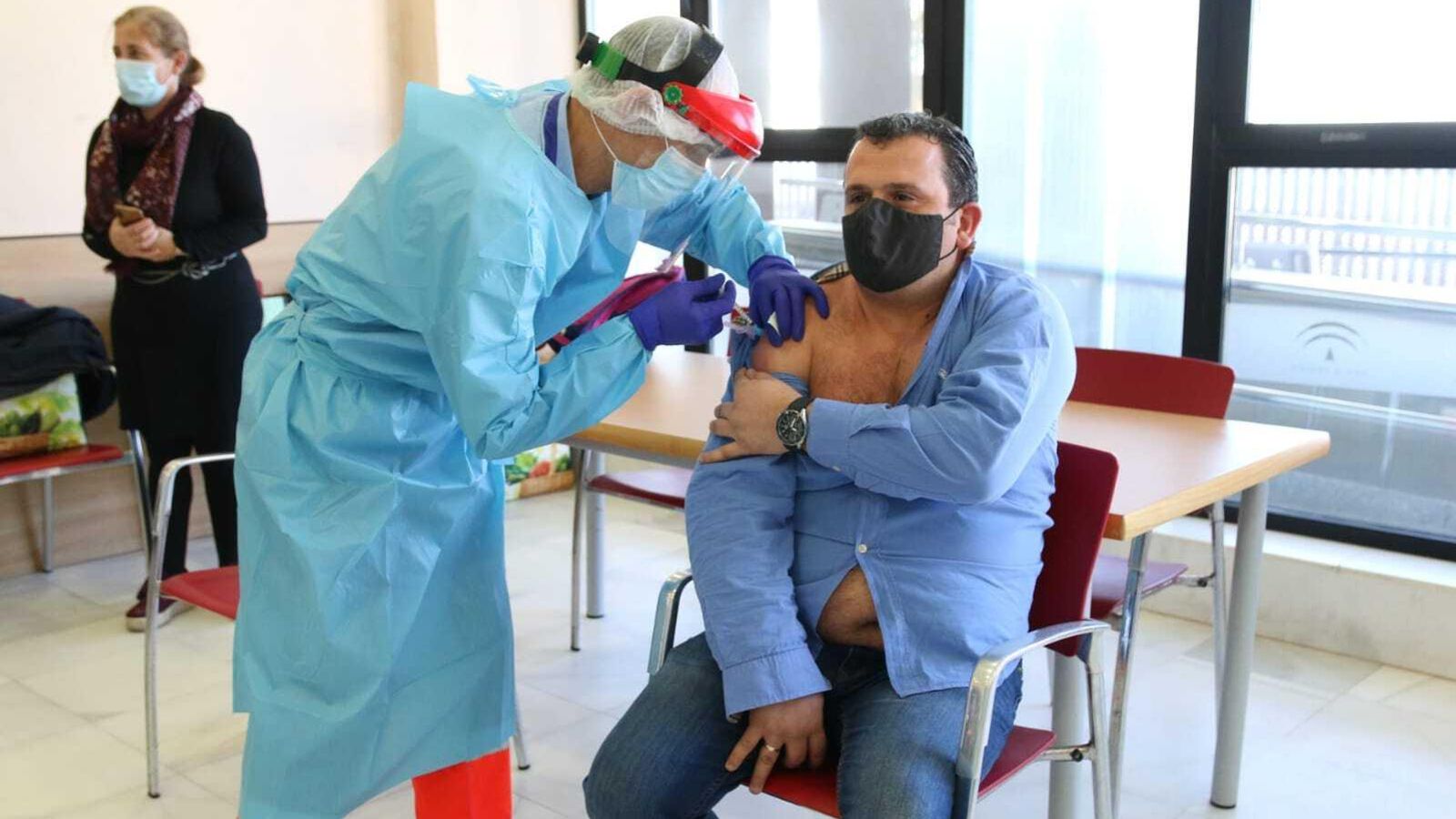 Un trabajador del centro recibe la vacuna.