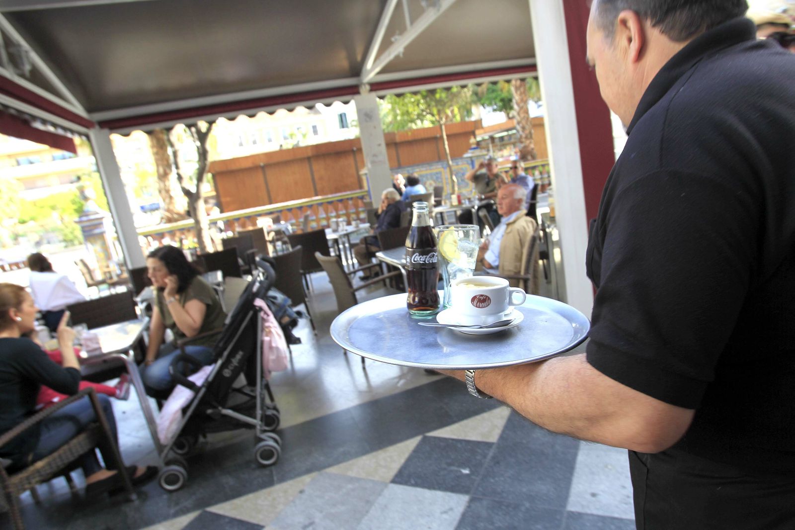 Un camarero atiende a unos clientes en una terraza