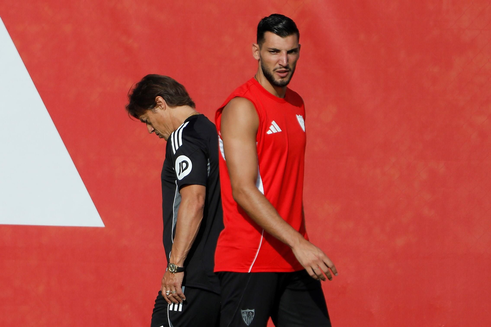 Almeyda mira al suelo al pasar al lado de Rafa Mir.