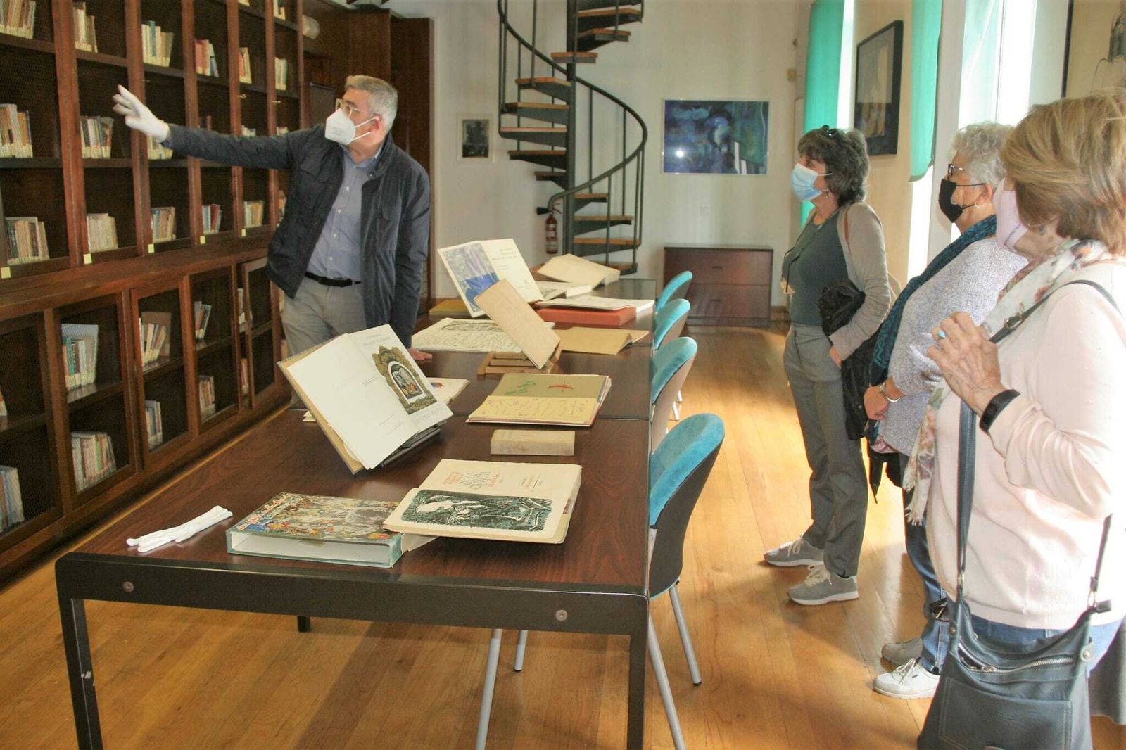 El trabajador de la Fundación Rafael Alberti, Enrique Pérez, mostrando la biblioteca a unas visitantes.