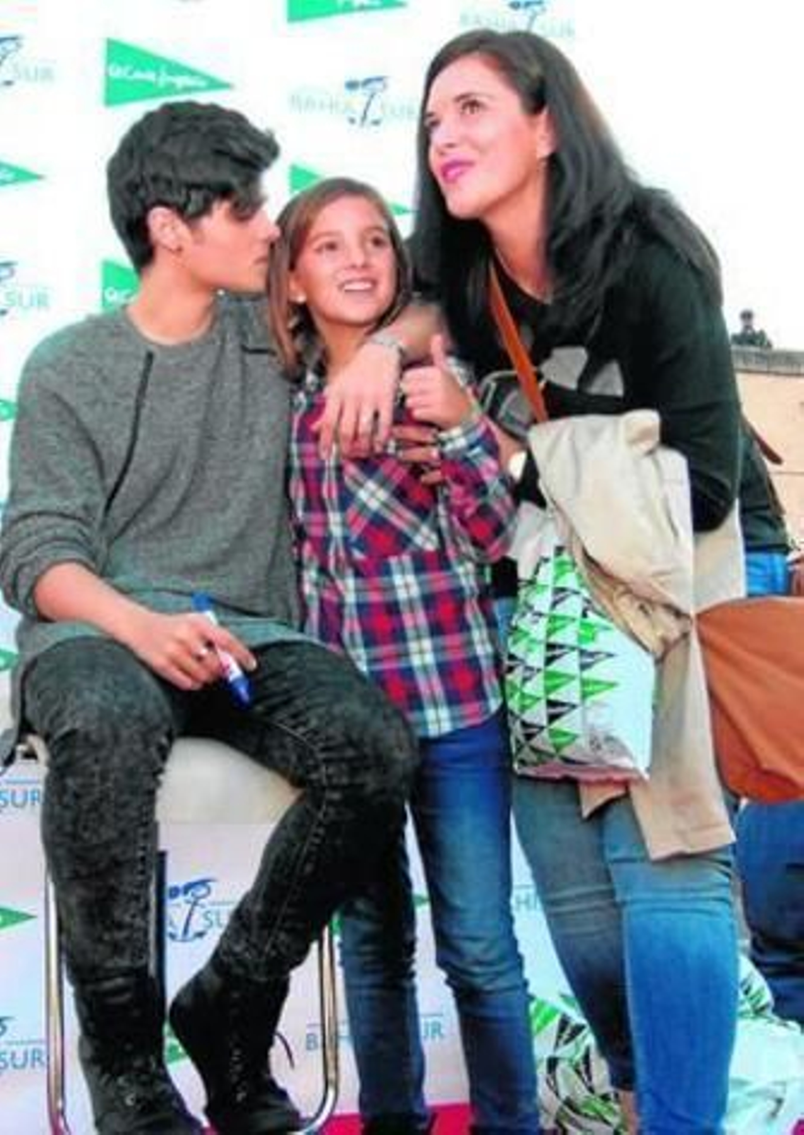 Abraham Mateo con una chica y su madre, posa para una foto.