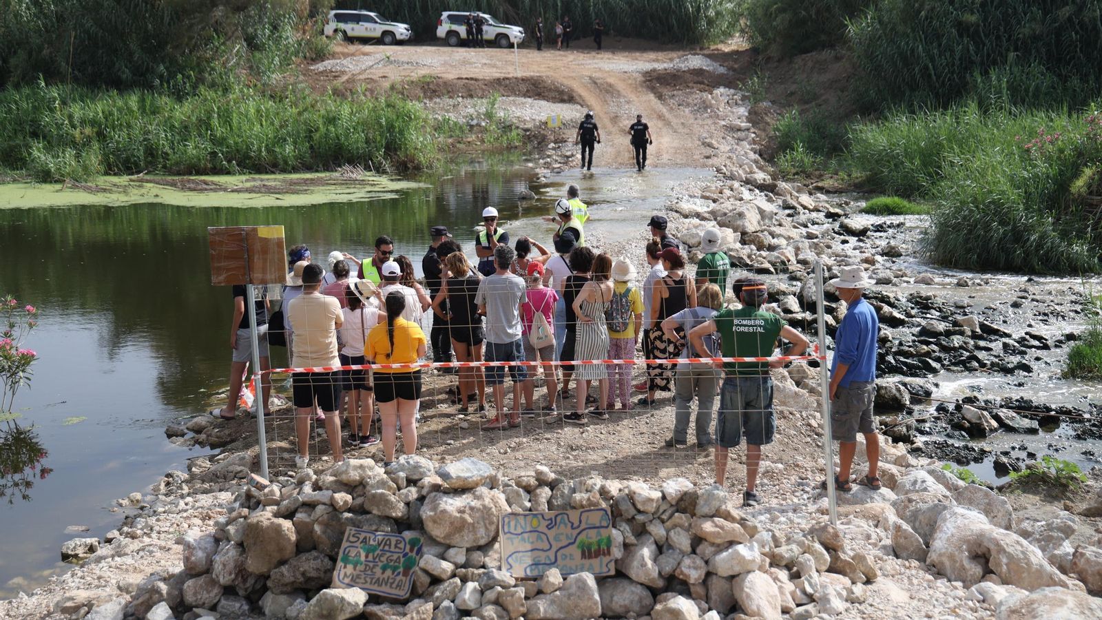 Los vecinos, contenidos por la policía, a un lado de la pasarela.