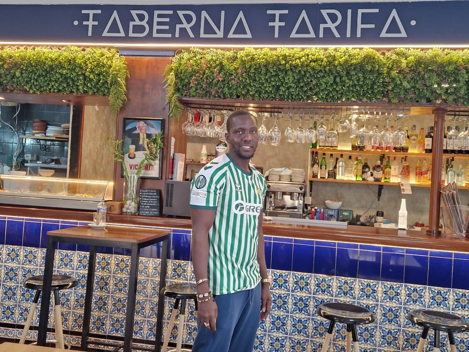 Moussa Niang posa frente a la barra de su bar en Marbella, Taberna Tarifa.