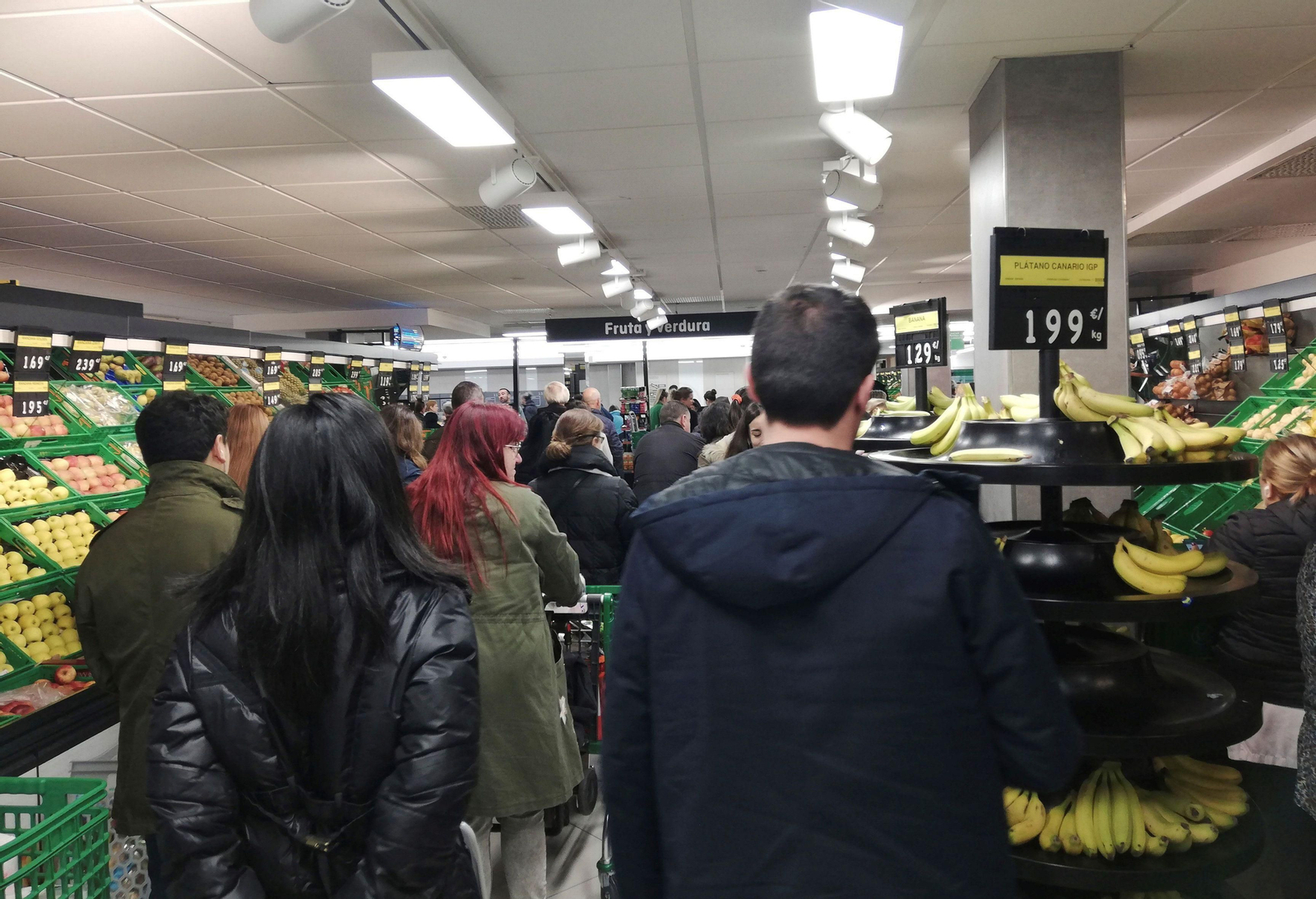 Un nutrido grupo de personas en la zona de frutería de un Mercadona.
