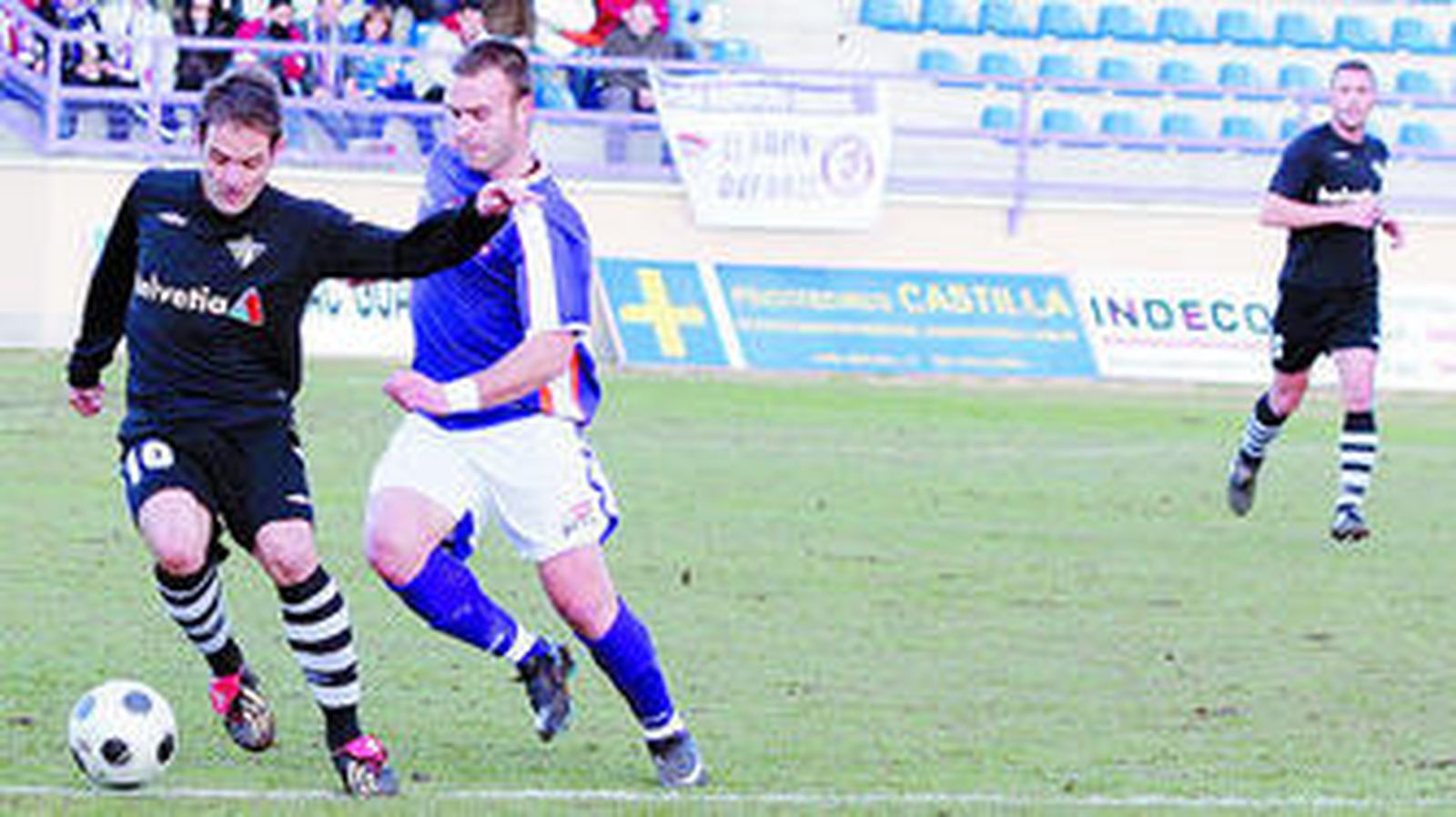 Requena controla el balón ante la presión de un rival.