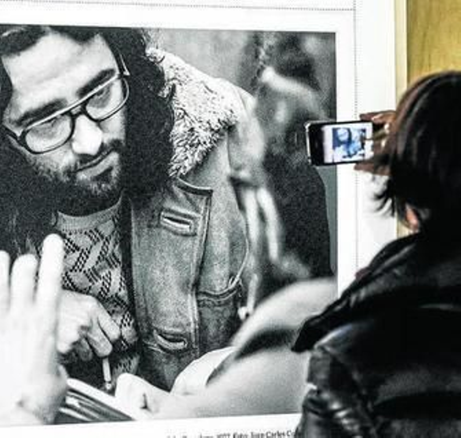 Una mujer retrata una instantánea de la exposición sobre Bolaño.