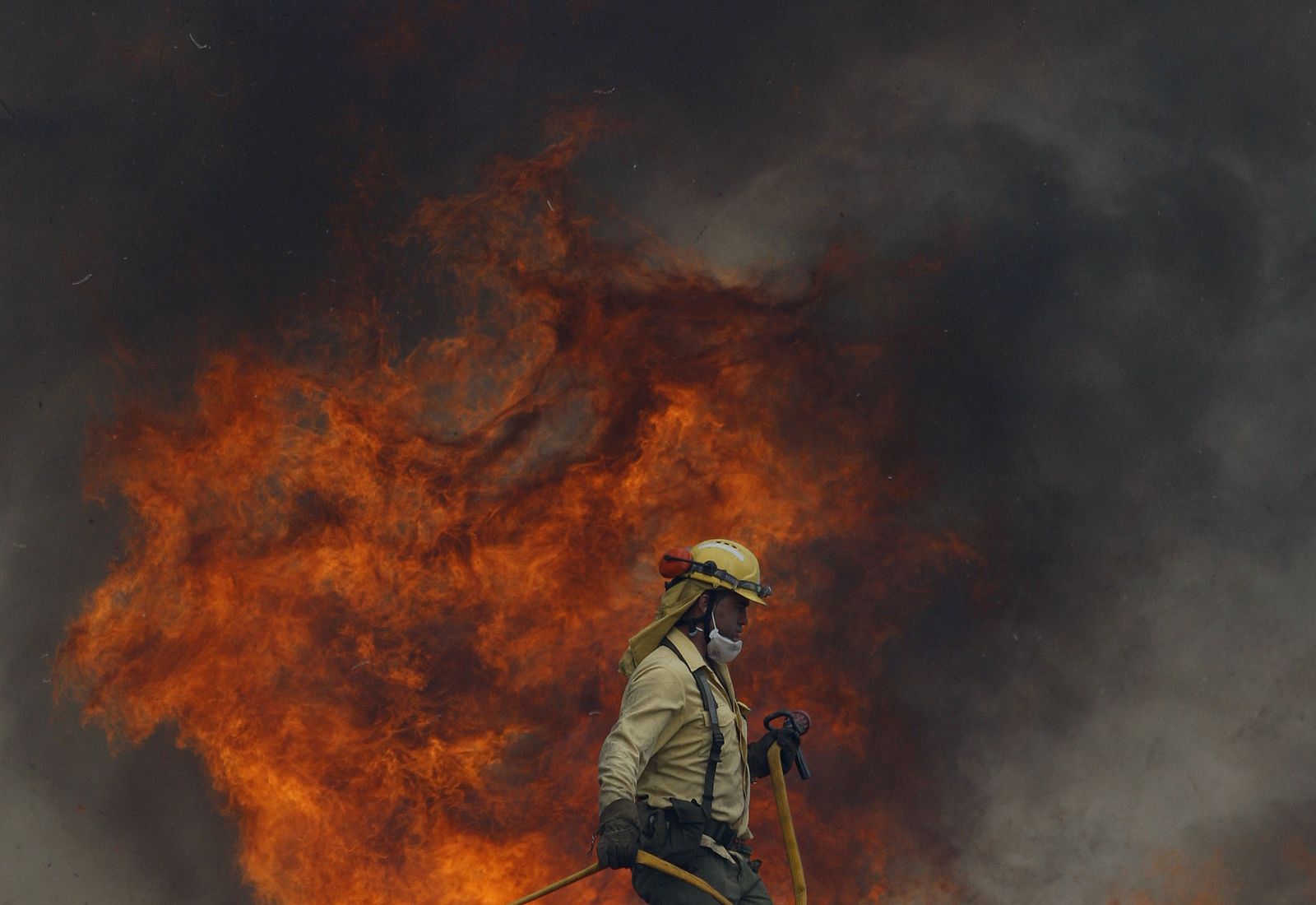 Bombero junto a una llama del incendio de Barranco Blanco.