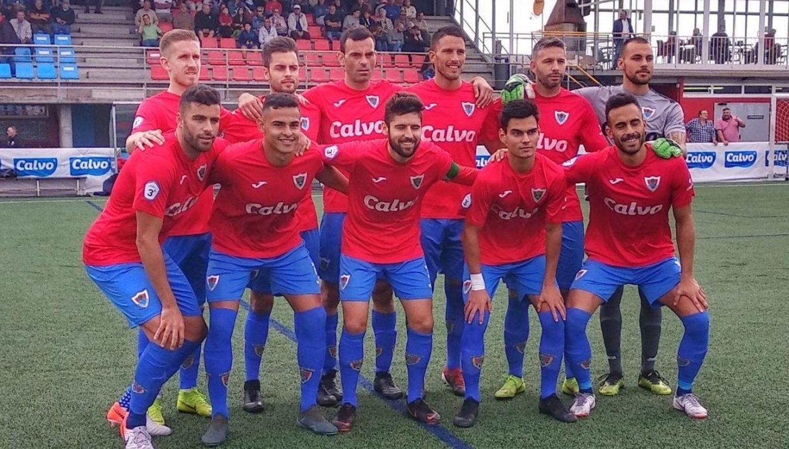 Formación del Bergantiños en el Municipal As Eiroas, con la publicidad de Calvo.