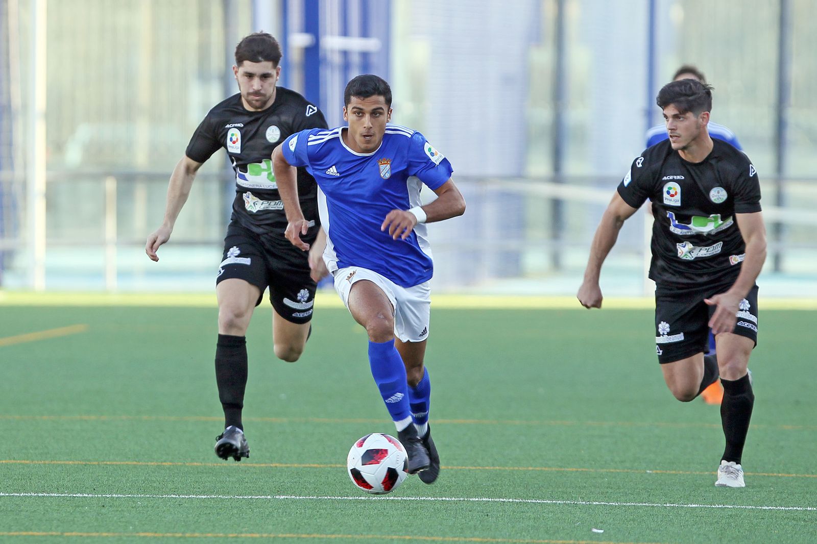 Dos jugadores del Ciudad de Lucena persiguen a uno del Xerez CD.