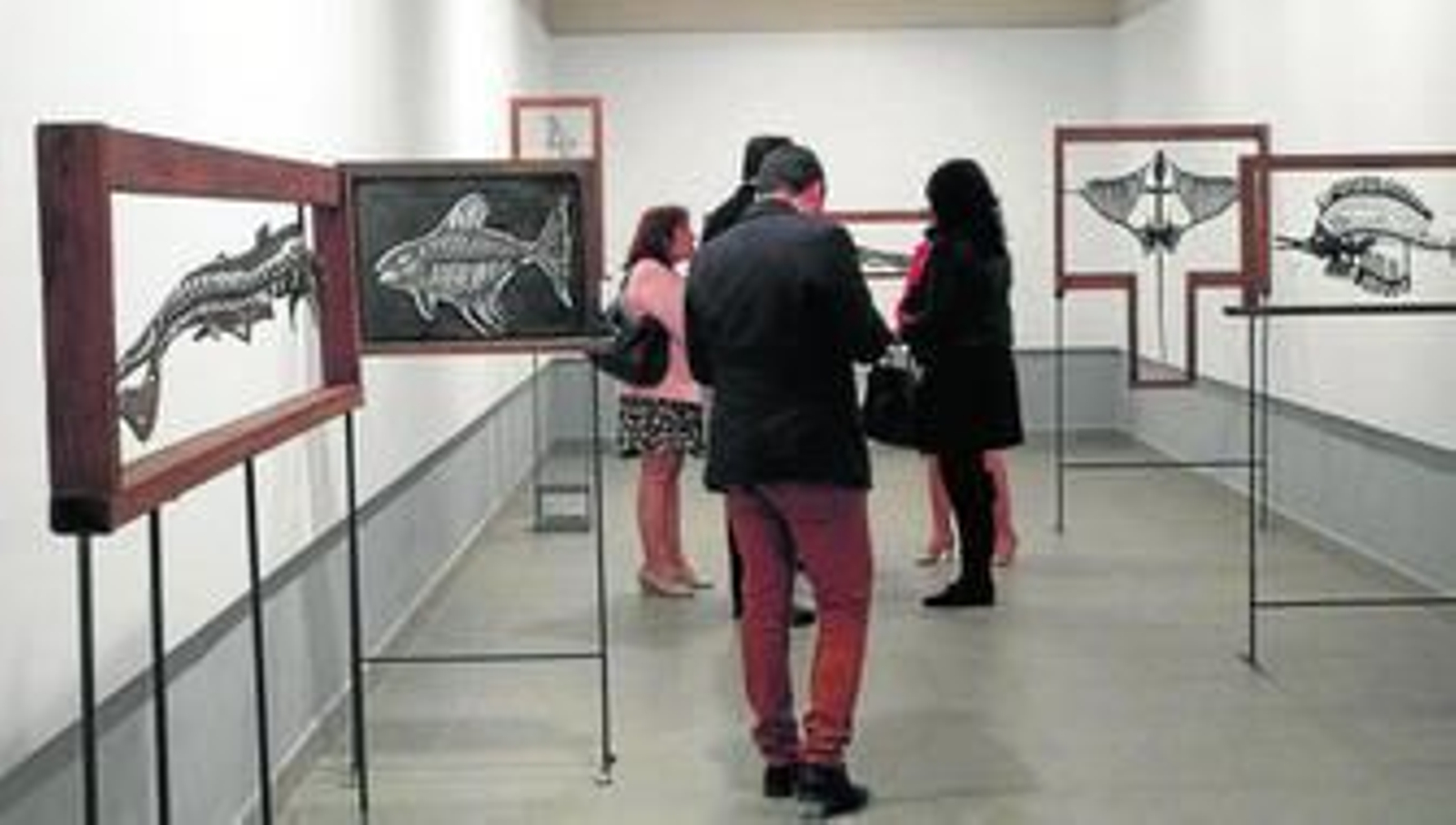 Algunas de las obras de la exposición de Emilio Rodríguez, que aparece en la fotografía de la derecha.