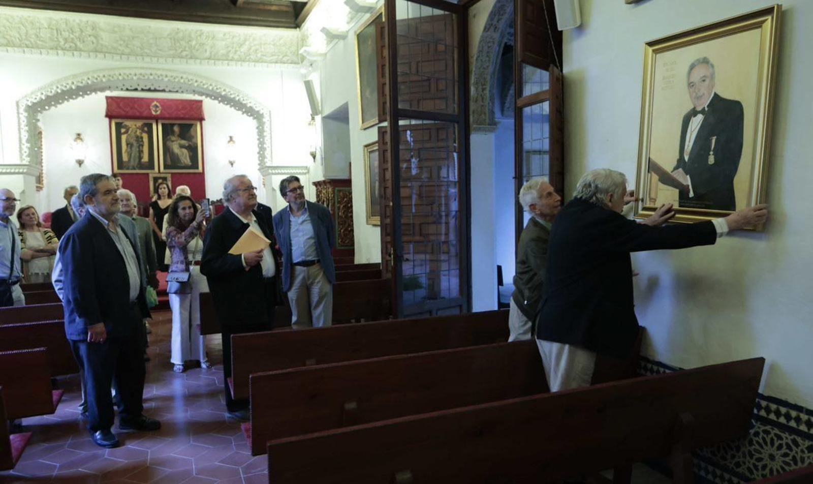 Los académicos Enrique Valdivieso y Antonio Collantes de Terán colocan el cuadro en el Salón de Actos de la Real Academia de Buenas Letras