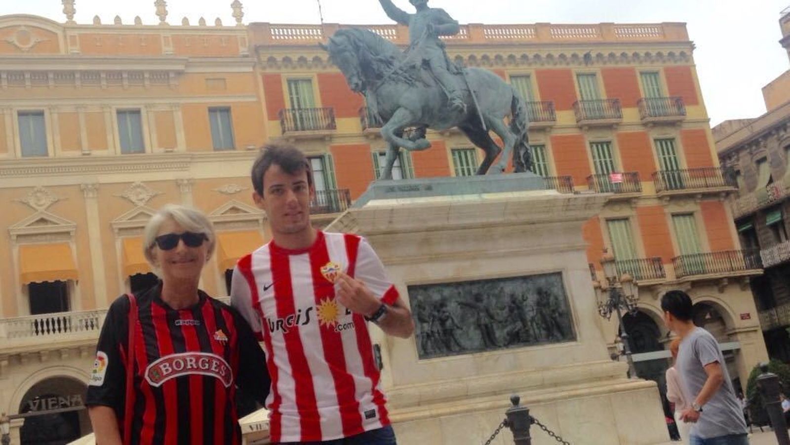 Eric, de rojiblanco, junto a su madrina, Encarna, en la Plaza de Prim, donde el Reus hace sus celebraciones.