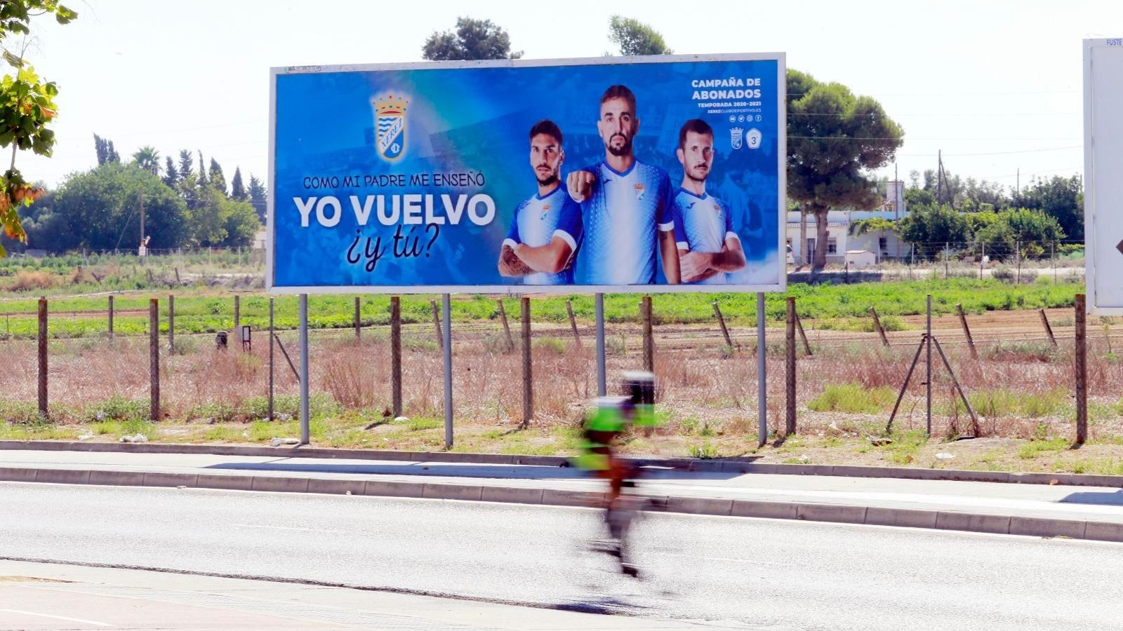 Un ciclista pasa junto a una de las vallas que anuncian la campaña de abonados del XCD.
