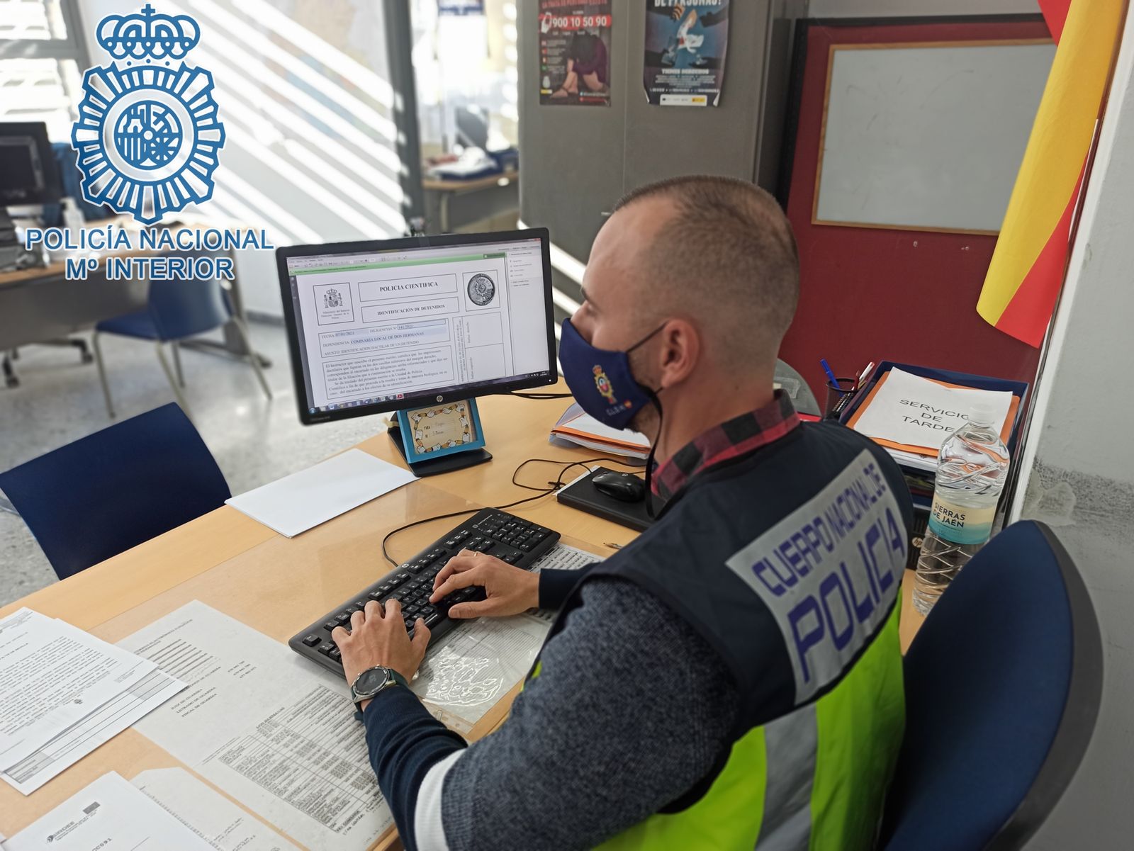 Un policía consulta documentación en un ordenador.