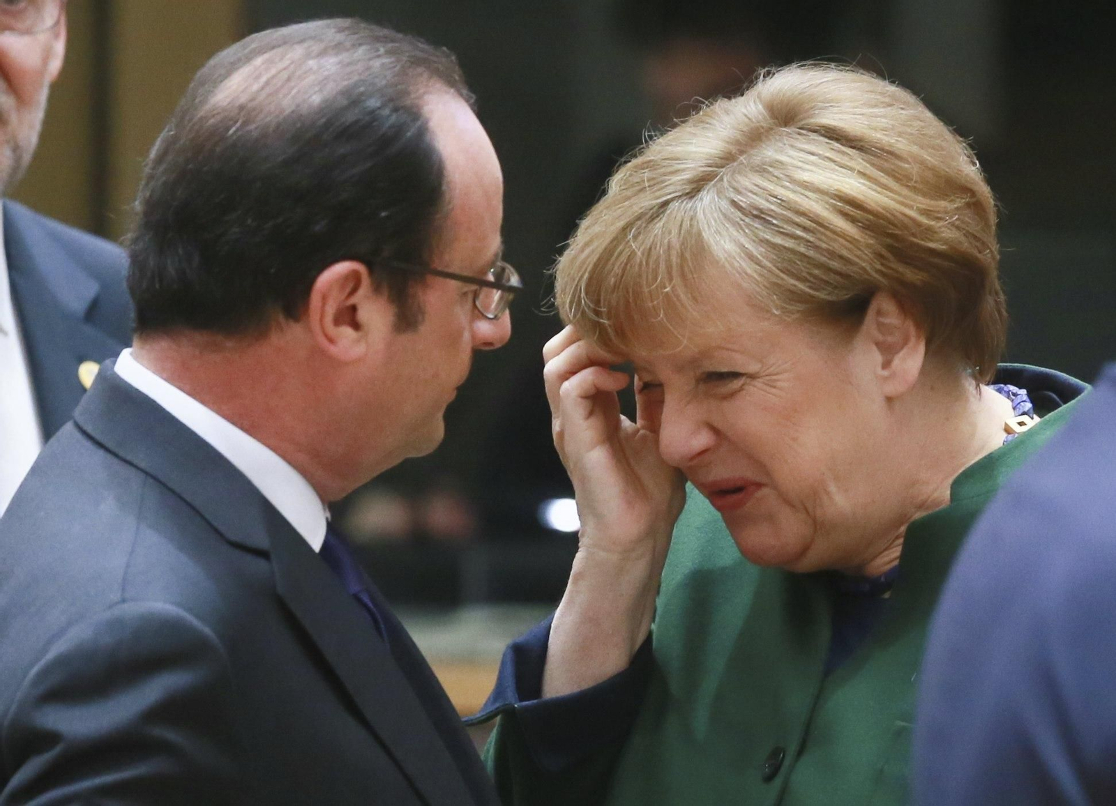 Hollande y Merkel hablan en un momento de la cumbre en Bruselas.