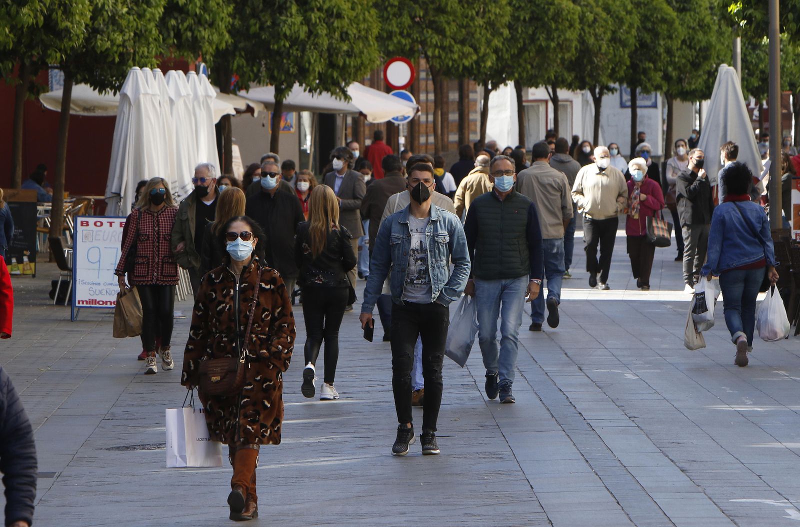 Multitud de personas transitan la calle San Jacinto, en Triana.