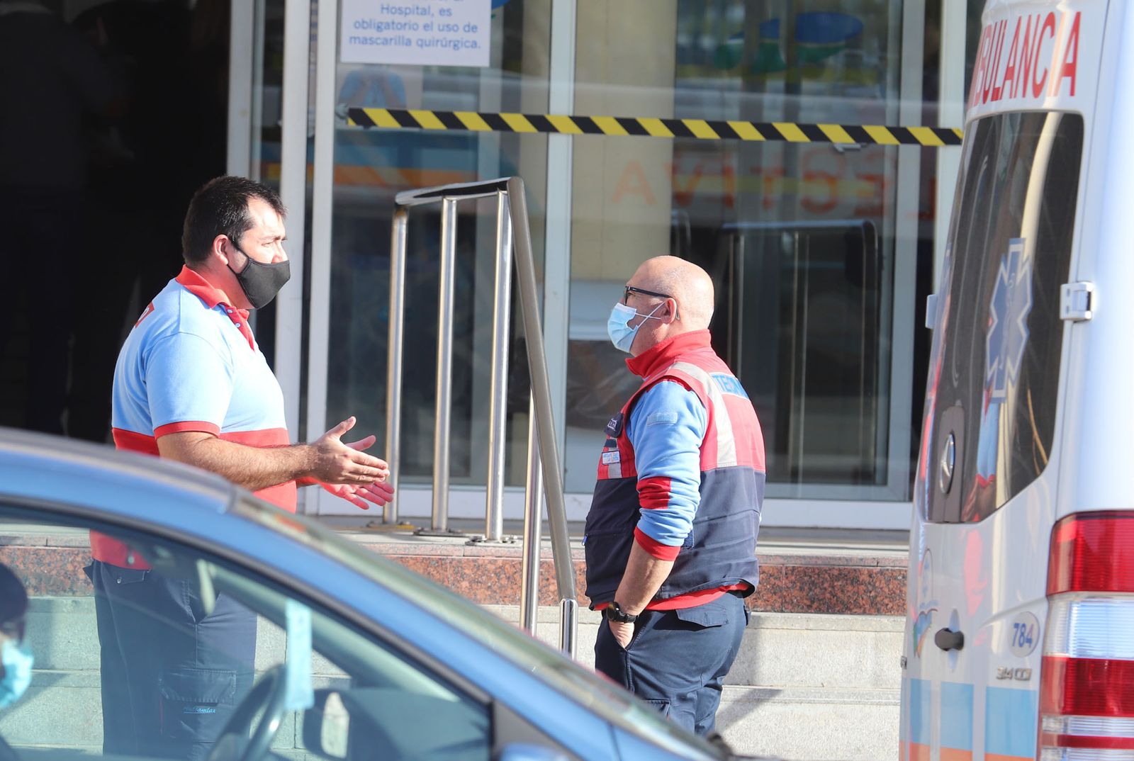 Dos sanitarios conversan a las puertas del Hospital Juan Ramón Jiménez.