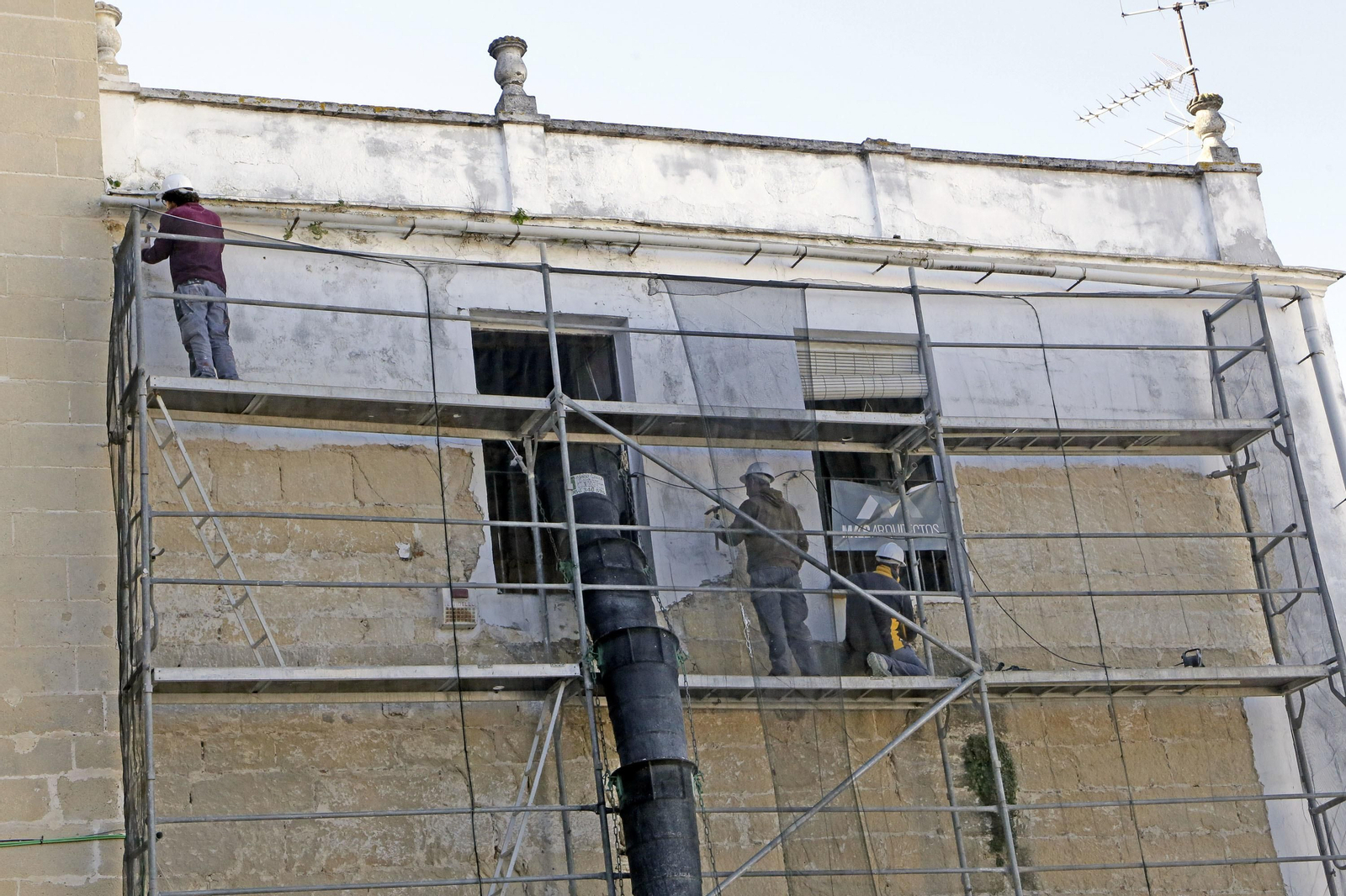 Obreros de la construcción adecentan una fachada en el centro. El mal arranque de año de los servicios tira por tierra la recuperación del sector del ladrillo.