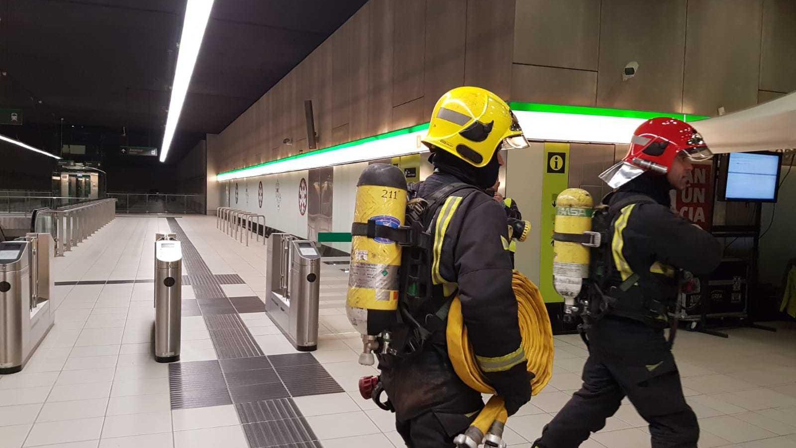 Dos bomberos participantes en el simulacro de accidente del Metro.