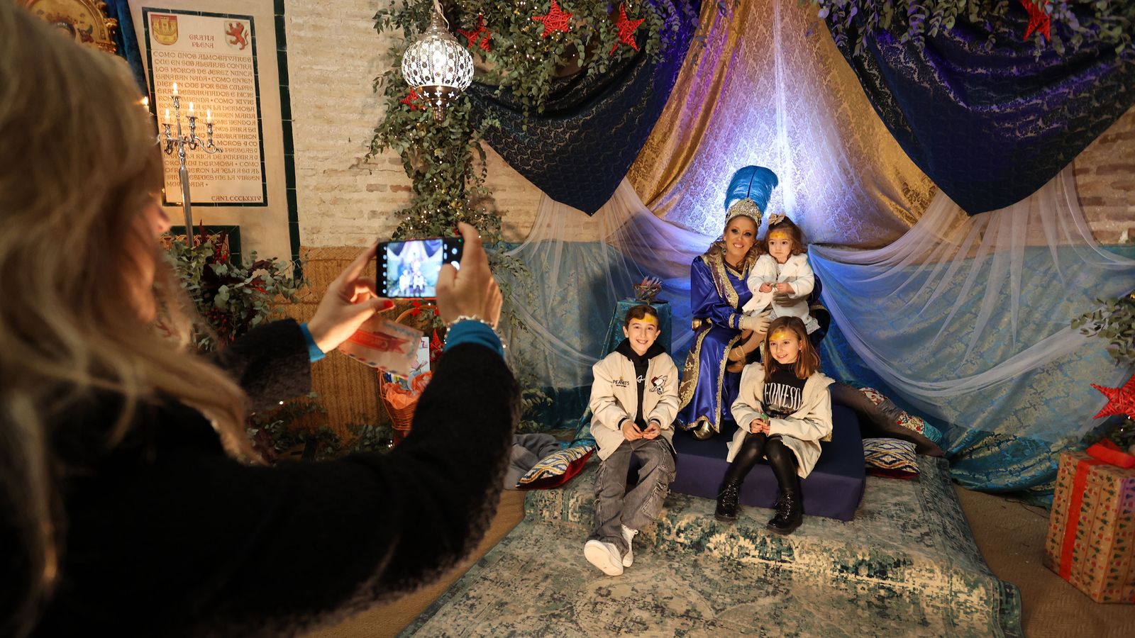 Una mujer fotografía a unos niños que han llevado sus cartas a la Cartera Real, en el Alcázar de Jerez.