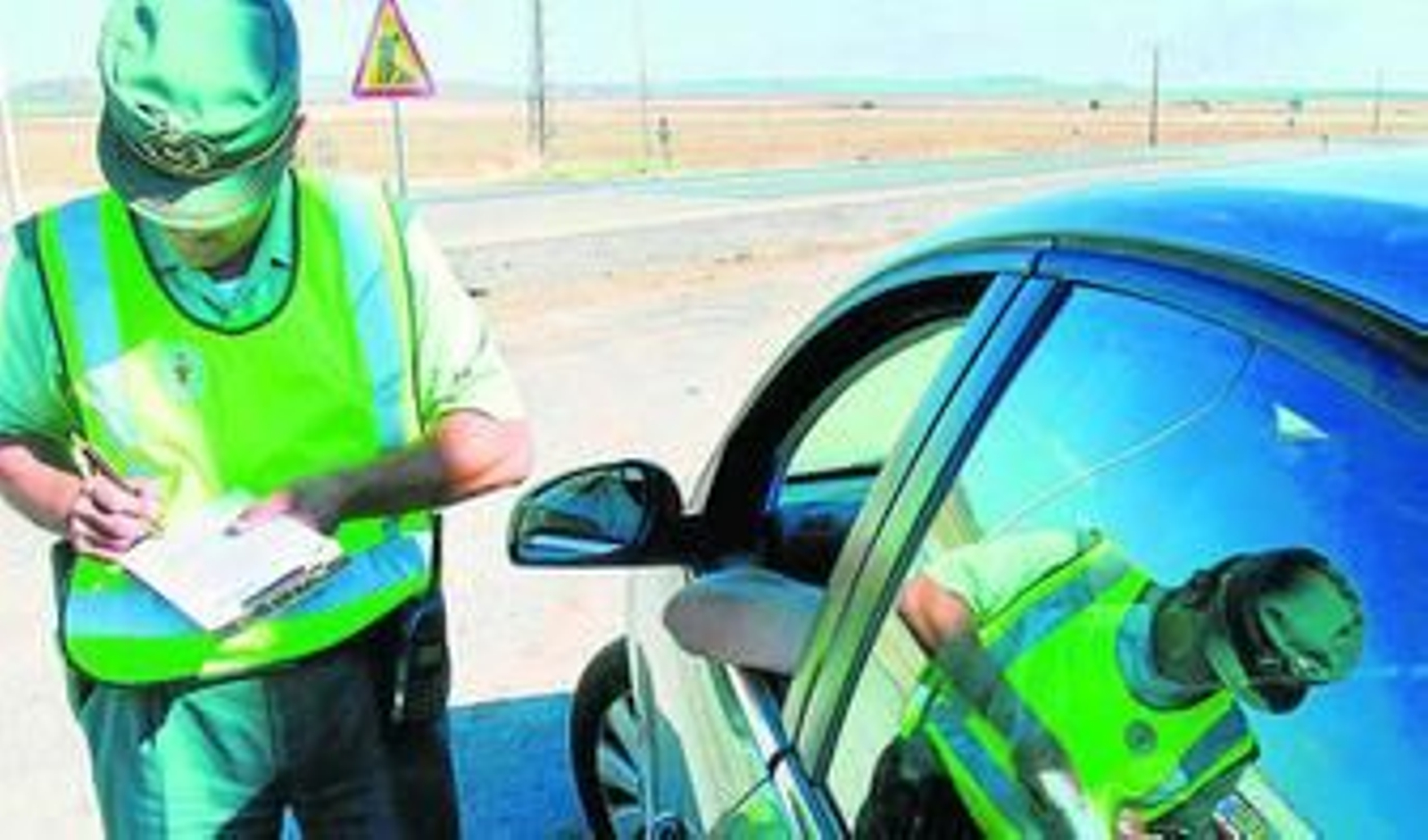 Un guardia civil interpone una multa a un conductor en una carretera de la provincia.