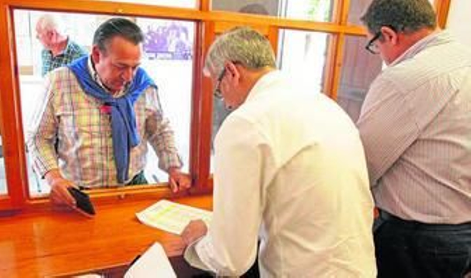 Varias personas comprueban las carretas en un listado, ayer en el Paseo.