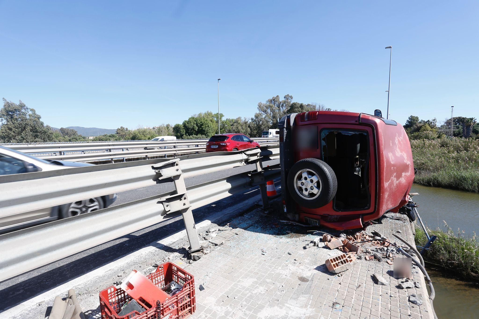 El todoterreno, volcado en el puente sobre el río Guadarranque.