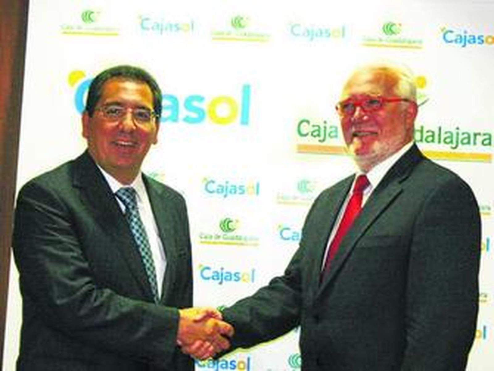 El presidente de Cajasol, Antonio Pulido, saluda a su homólogo en Caja Guadalajara, José Luis Ros.