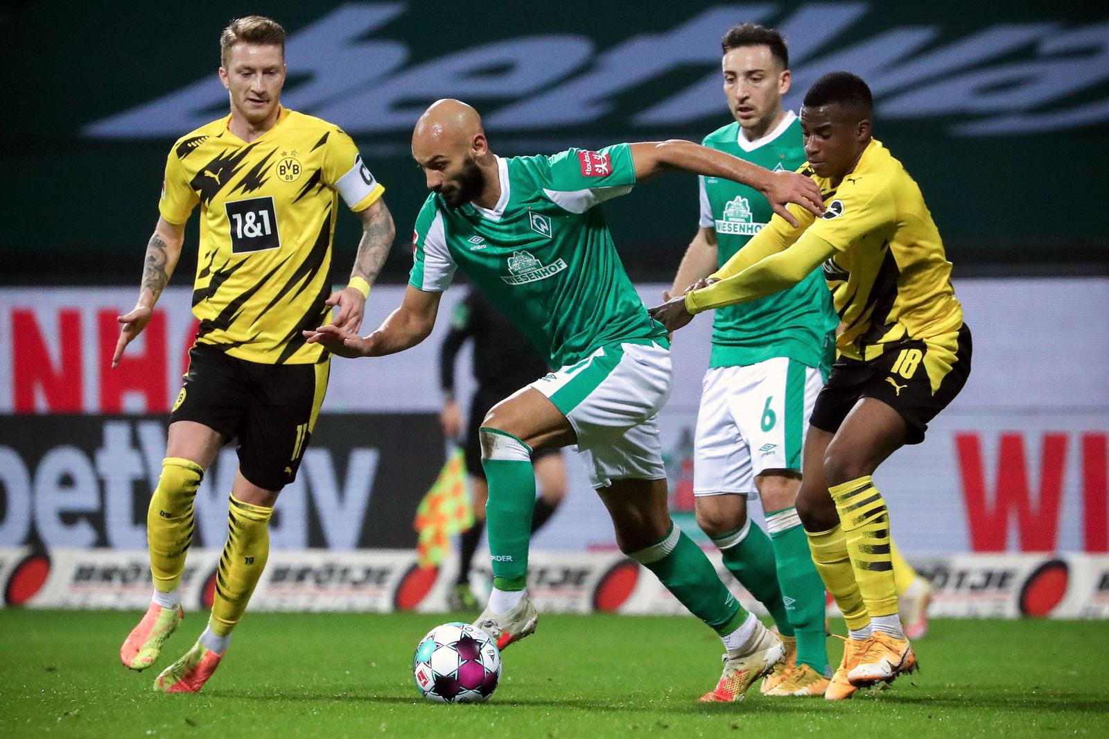 Moukoko acosa a Toprak ante Reus en el triunfo del Dortmund en Bremen.