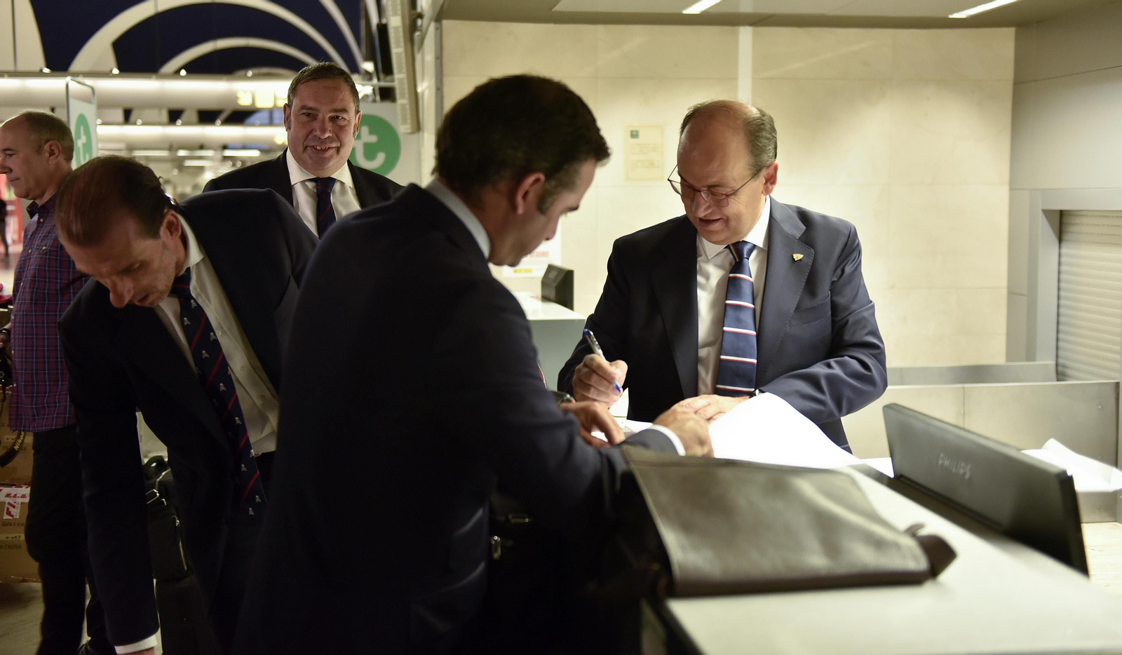 José Castro firma unos documentos en el aeropuerto antes de partir hacia Estambul en presencia de Óscar Arias, Jesús Arroyo y Jesús Gómez.