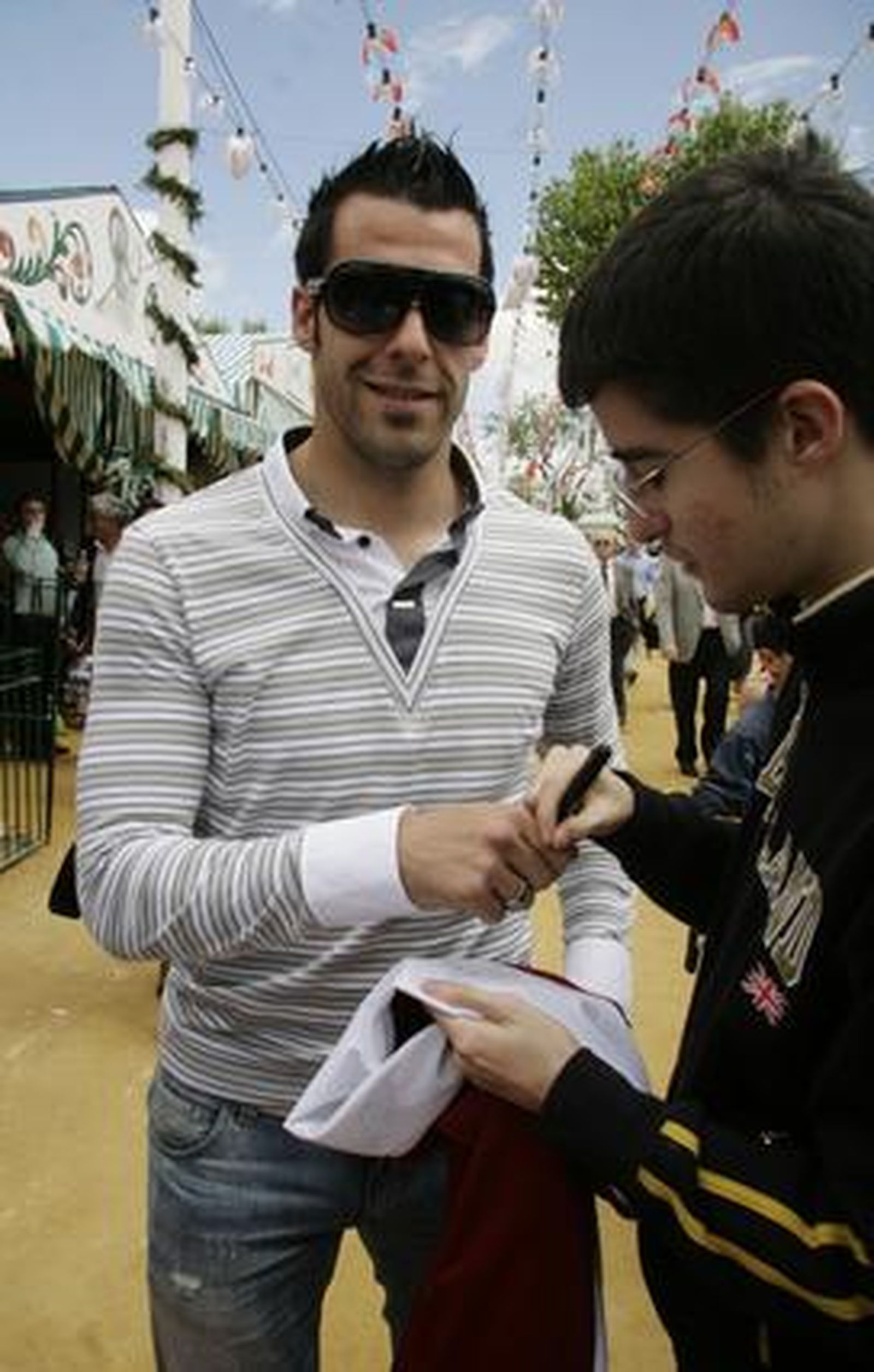Álvaro Negredo le firma la camiseta a un joven en el real.

Foto: Victoria Hidalgo