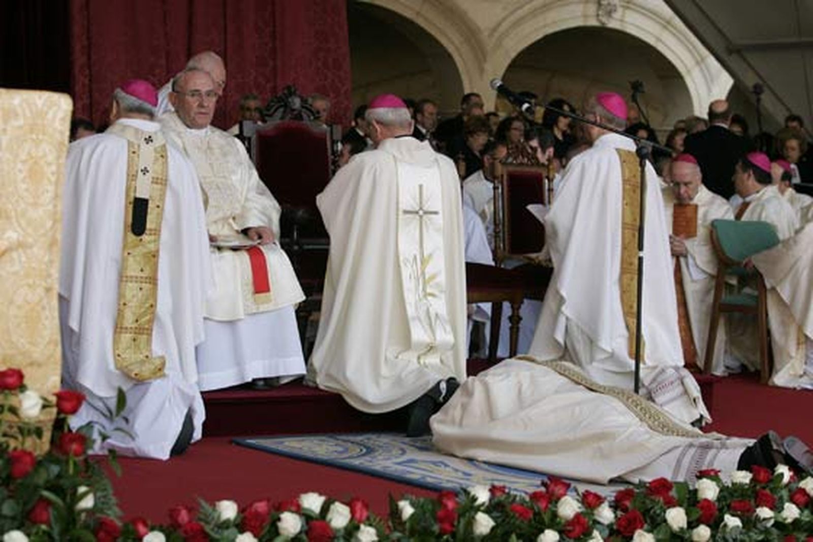 El obispo, postrado en el suelo, observado por su predecesor.

Foto: Javier Alonso