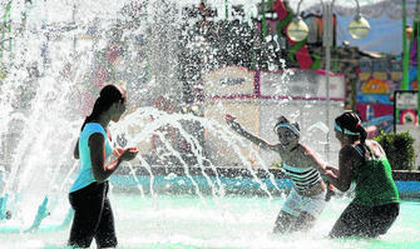 Varias jóvenes refrescándose en una fuente del Real de Cortijo de Torres.
